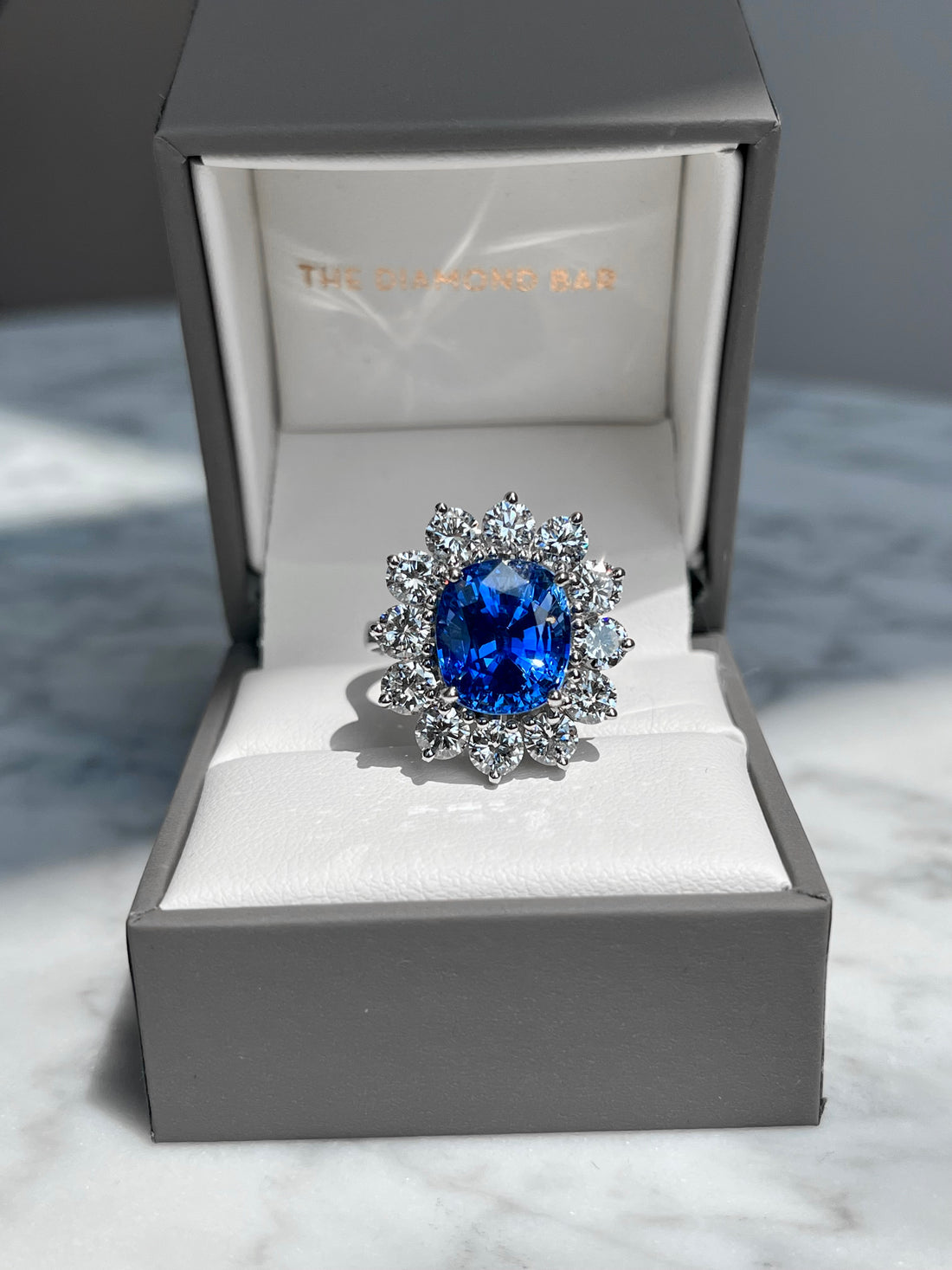 Custom Platinum Blue Sapphire and Diamond Halo Ring Designed By Chris Phillips at The Diamond Bar